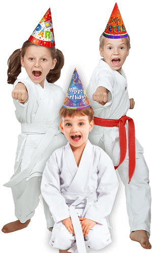 Three kids in karate uniforms wearing birthday hats